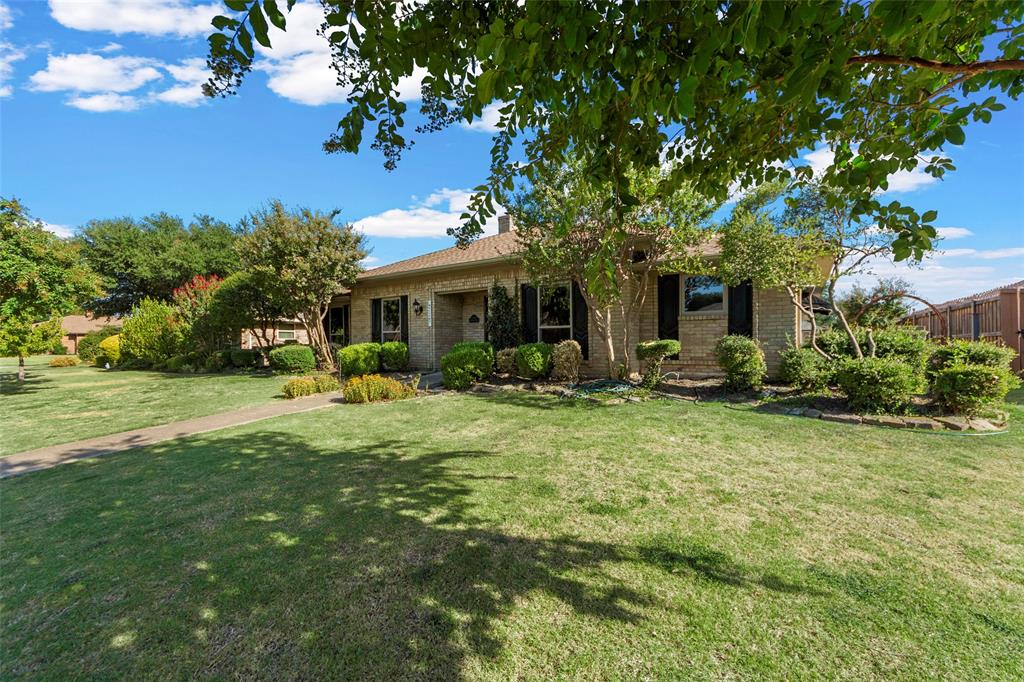 Brick exterior, manicured lawn, established landscaping, walkway, mature trees