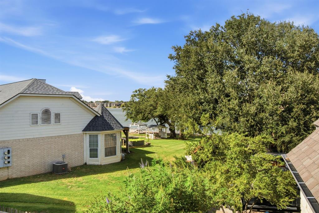 View with mature trees from the upstairs covered balcony looking out onto Lake Granbury