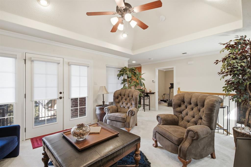 Upstairs living area featuring a central multi-light ceiling fan, recessed lighting, and glass-paned doors that goes onto the upstairs patio overlooking Lake Granbury