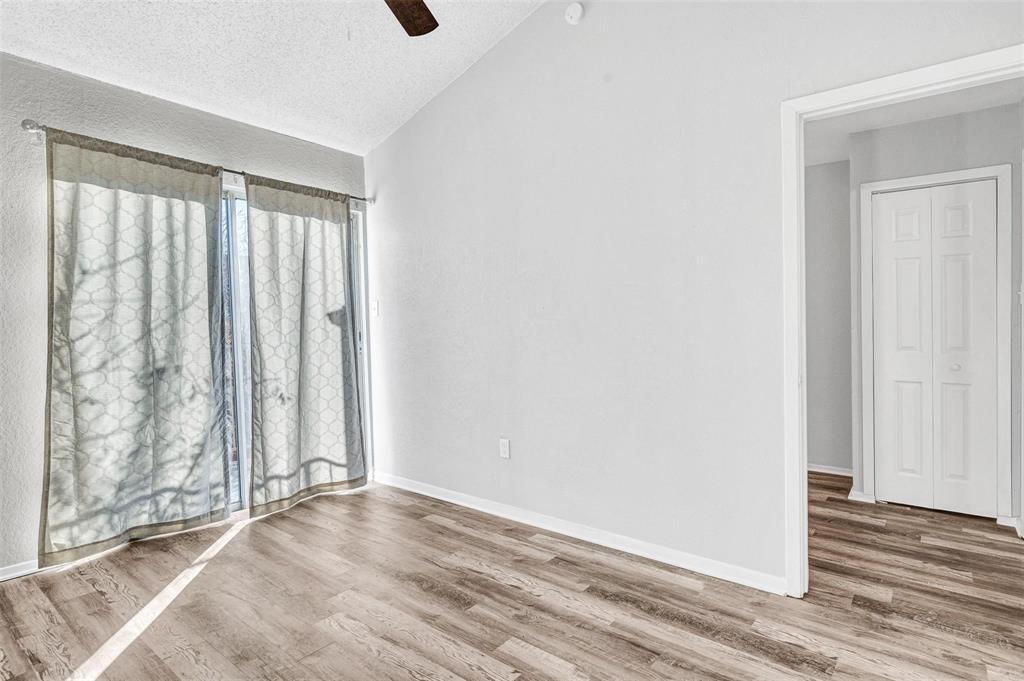 Primary bedroom with ceiling fan and balcony access.