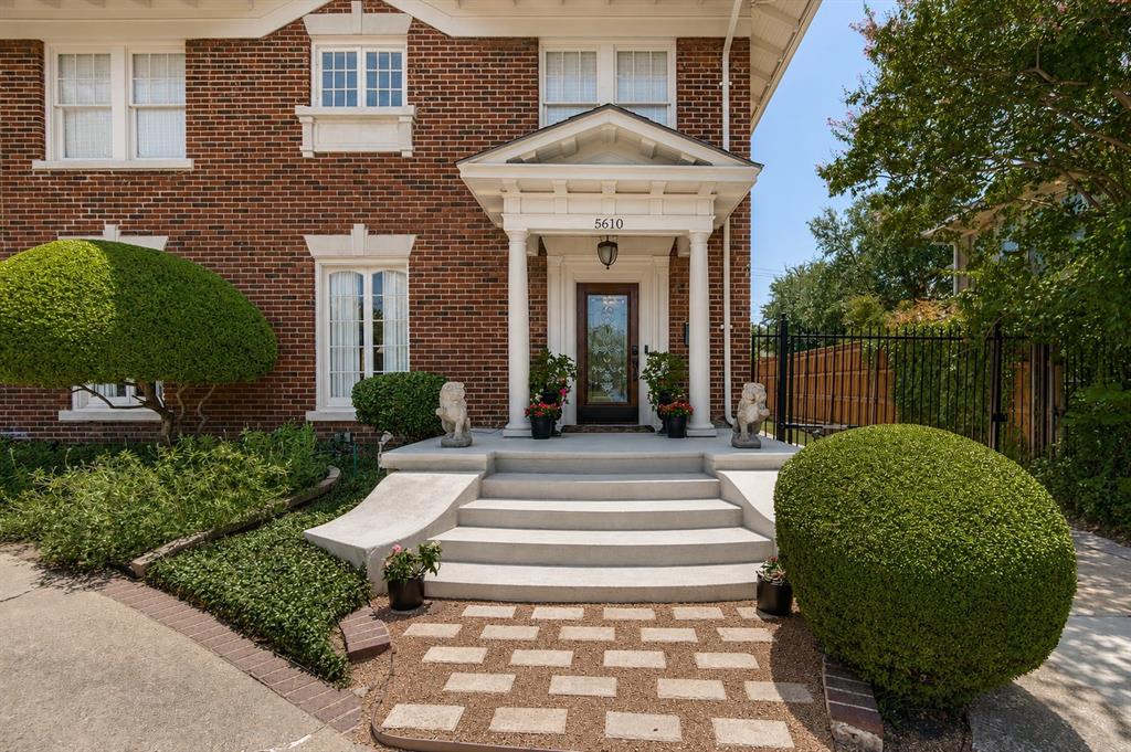 Brick exterior with stone window sills, a covered entry with columns, and concrete stairs