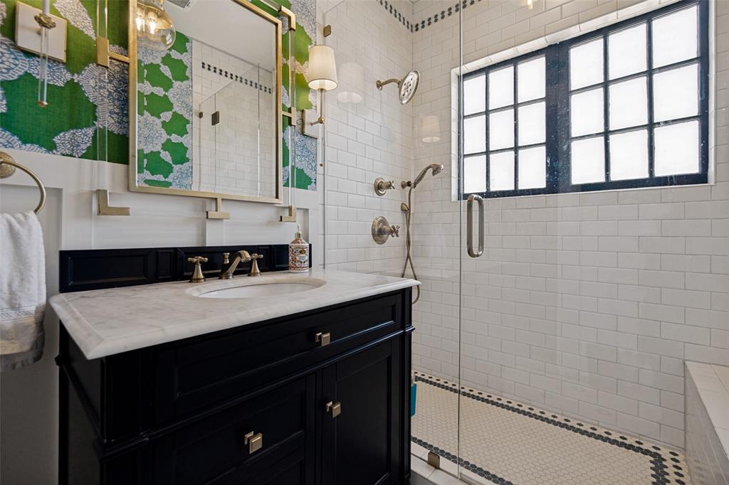 Black vanity with a white countertop and brass hardware