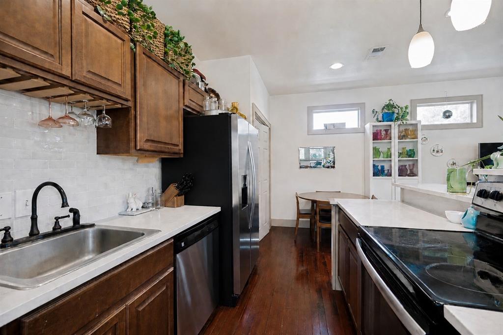 Dark wood-finish flooring, ceiling fan with integrated lighting, built-in shelving, and a paneled interior door