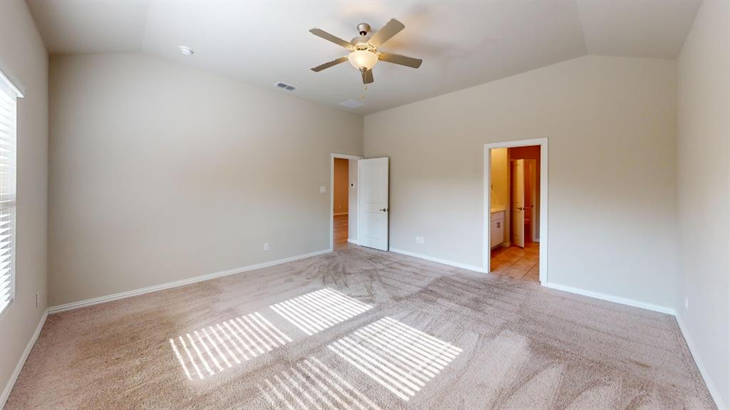 Vaulted ceiling, ceiling fan with integrated lighting, window with blinds, light-colored carpeting, and a white interior door