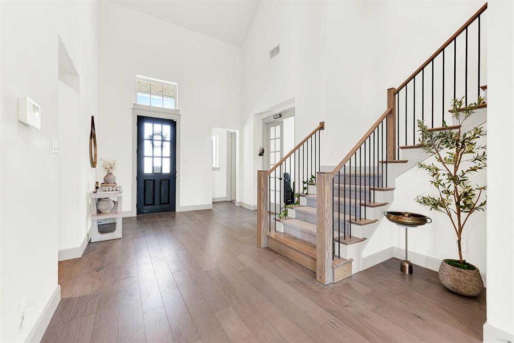 A grand, soaring ceiling pairs with a glass-paneled front door that floods the light wood floors with soft natural sunshine. It’s the perfect spot to kick off your shoes and welcome family home after a long day. A grand, soaring ceiling pairs with a glass-paneled front door that floods the light wood floors with soft natural sunshine. It’s the perfect spot to kick off your shoes and welcome family home after a long day.