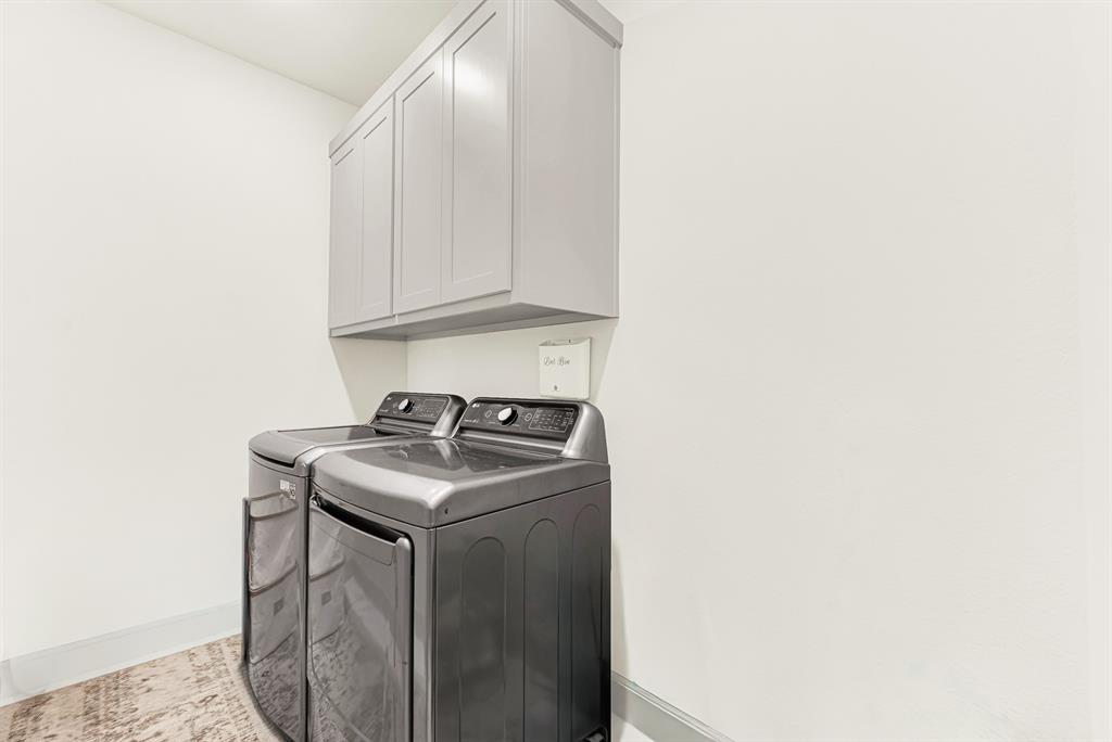 Mounted upper cabinetry floats neatly above bright, crisp walls to maximize vertical space and reflect surrounding light. You can easily stay on top of weekly family chores in a clean, hassle-free environment.