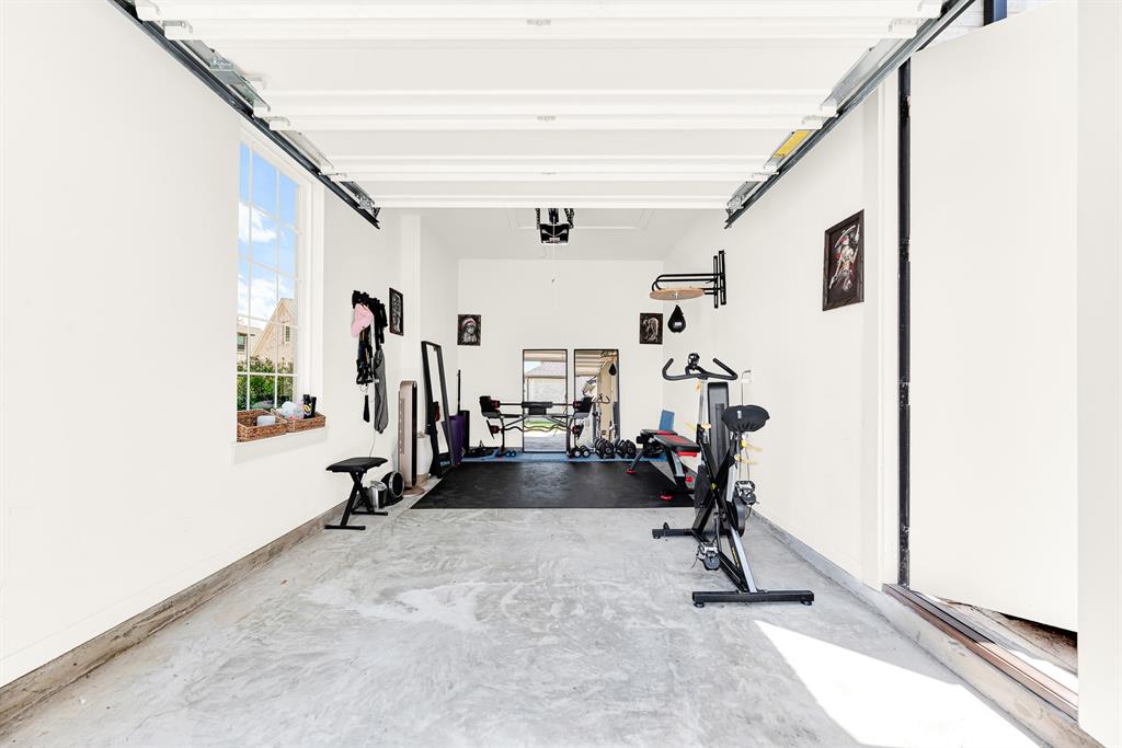 High ceilings and a tall side window bring abundant daylight across smooth concrete flooring. You can crush an early morning workout or stretch out uninterrupted right in your own dedicated home space in the handy single car garage bay by the front door.