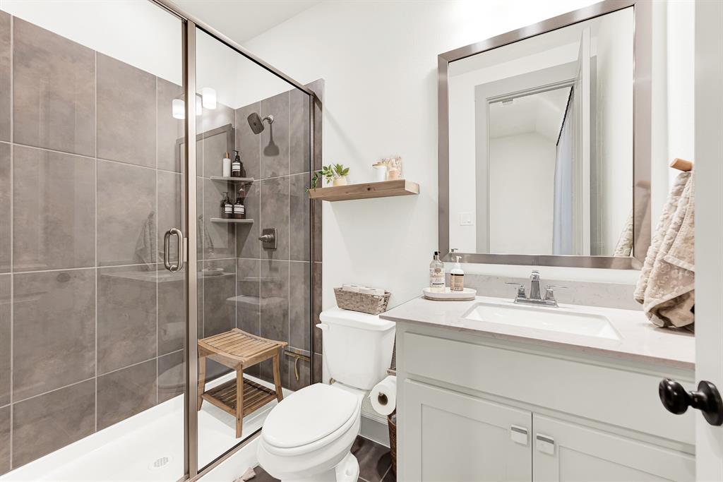 Sleek glass enclosures and rich floor-to-ceiling shower tiles create a modern design frame that catches bright, clean lighting. Visitors can wind down with a hot, spa-like rinse after a long day of travel, enjoying complete privacy and comfort.