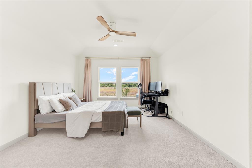 Slightly sloped ceilings and framed double windows direct natural light straight across the deep room layout. It offers an easy space to focus on homework or dive into a favorite book during quiet afternoon hours.