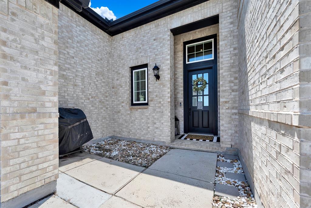 A sheltered alcove creates an inviting threshold with a glass-paned front door catching warm ambient rays. You can happily welcome old friends at the front doorstep for a laid-back weekend visit.