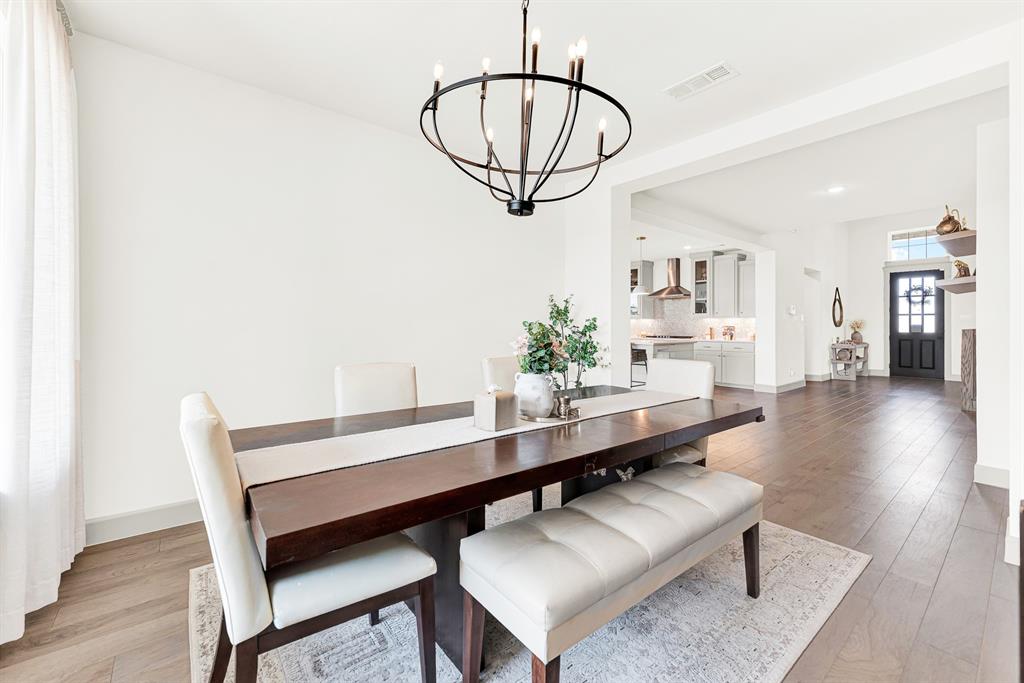 A wide cased doorway creates an effortless layout, linking the dining space directly to neighboring home hubs. Imagine enjoying celebratory family birthday toasts while easily serving fresh dishes from nearby counters.