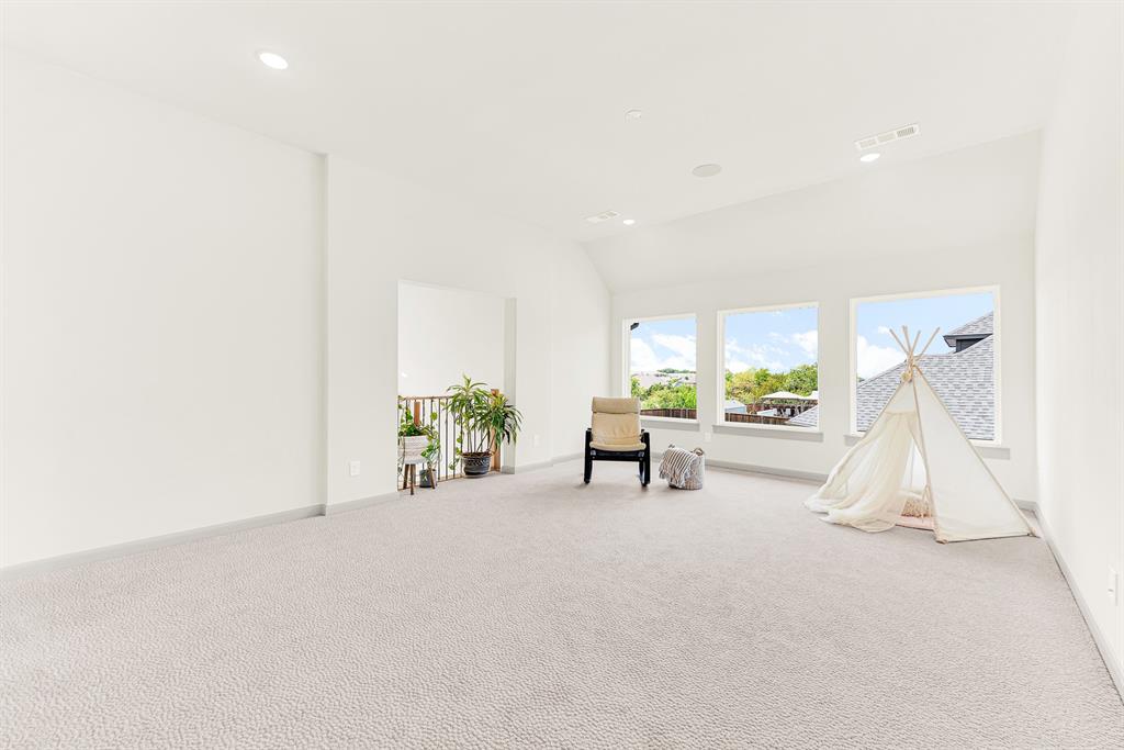 A trio of large windows fills the vaulted space with daylight and open sky views. Kids and adults alike can spend easy weekend afternoons playing board games bathed in warm sunshine