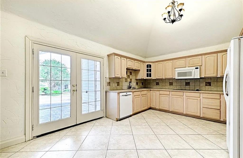 Spacious kitchen featuring wood-finish cabinetry, tile flooring, and stainless steel appliances