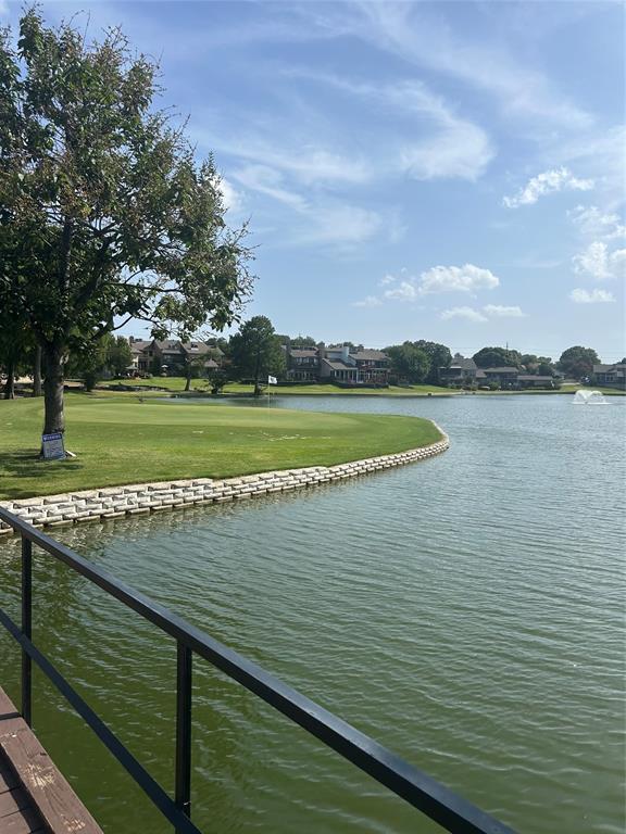 Lakefront property with a lush golf course, stone-retained shoreline, and a water feature