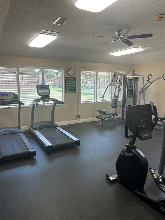 Dedicated community fitness room featuring multiple treadmills, stationary bike, and strength training equipment