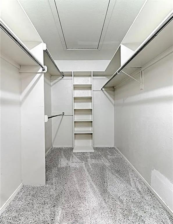Organized closet featuring a built-in shelving unit, multiple hanging rods, and light-colored carpet flooring
