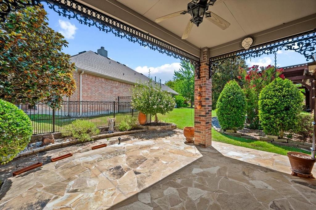 Extended flagstone patio, ceiling fan, decorative ceiling, trees and shrubs provide privacy