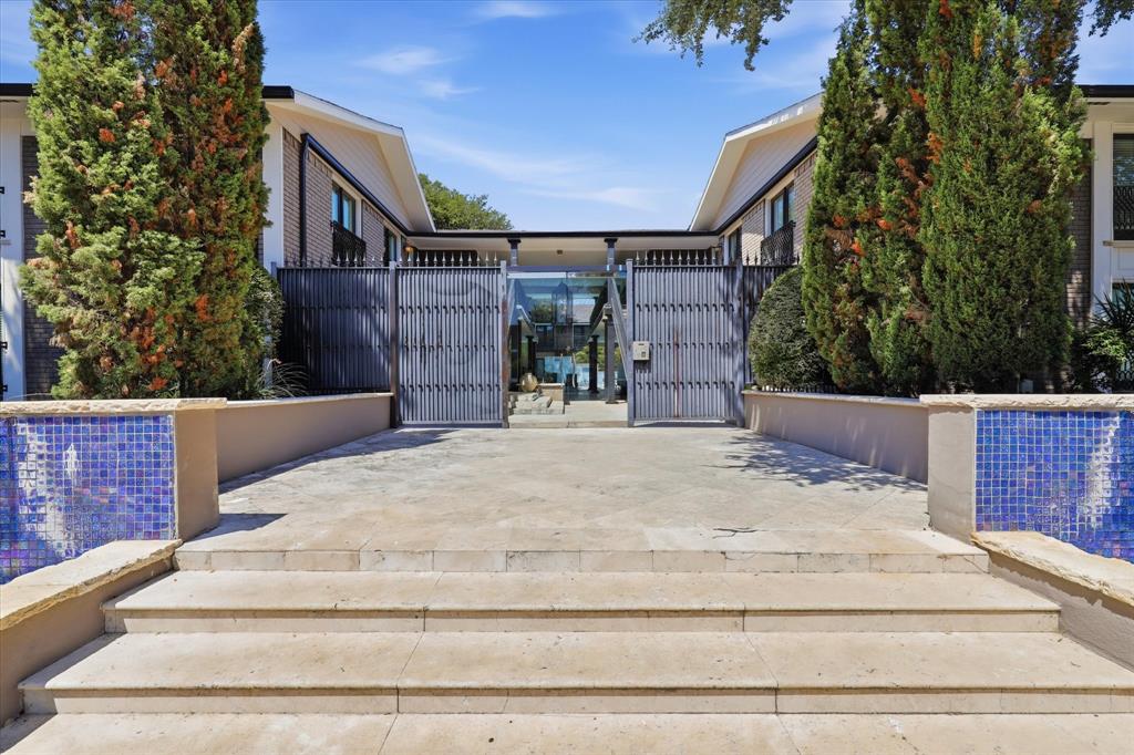 Gated entrance to the community framed by mature landscaping.