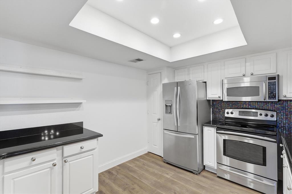 Another view of the kitchen showcasing the generous cabinetry, stainless steel appliances and functional workspace.