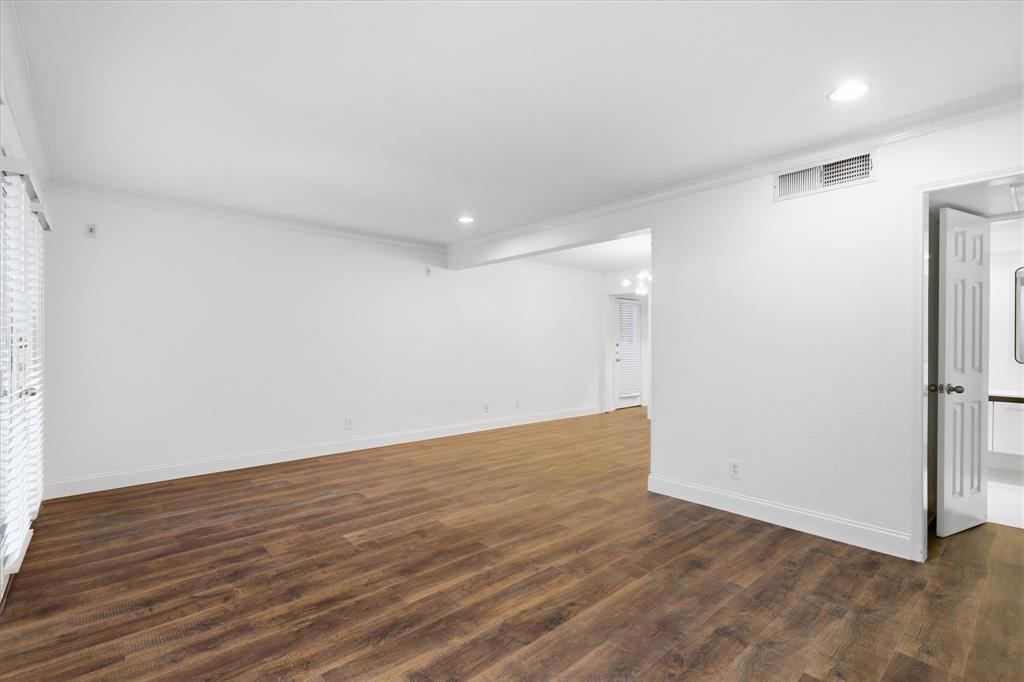 View of the living area  upon entry showing the recently updated flooring, baseboards and fresh neutral paint.