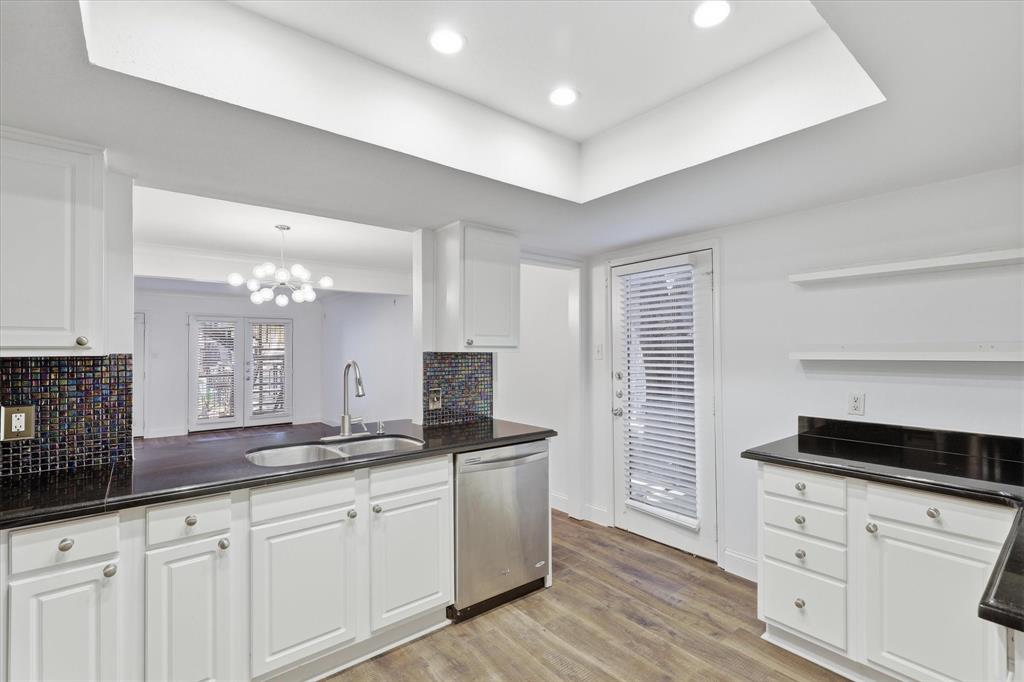 Kitchen view toward the rear entrance, with abundant cabinetry and counter space.
