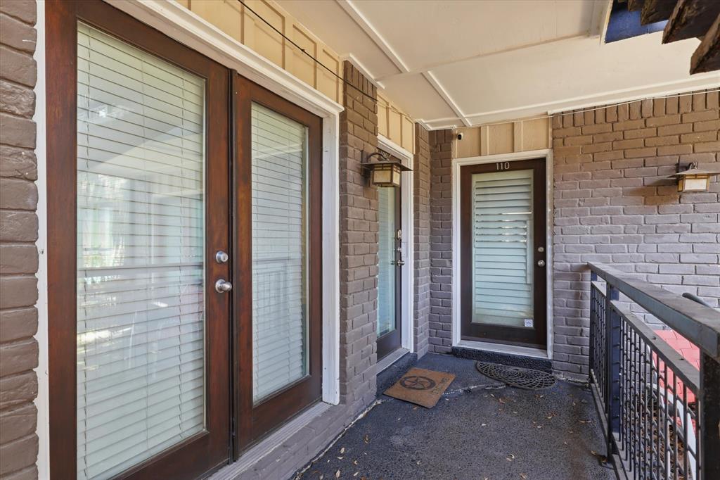 Covered exterior walkway leading to the condo, providing a view of the building’s courtyard-style setting.