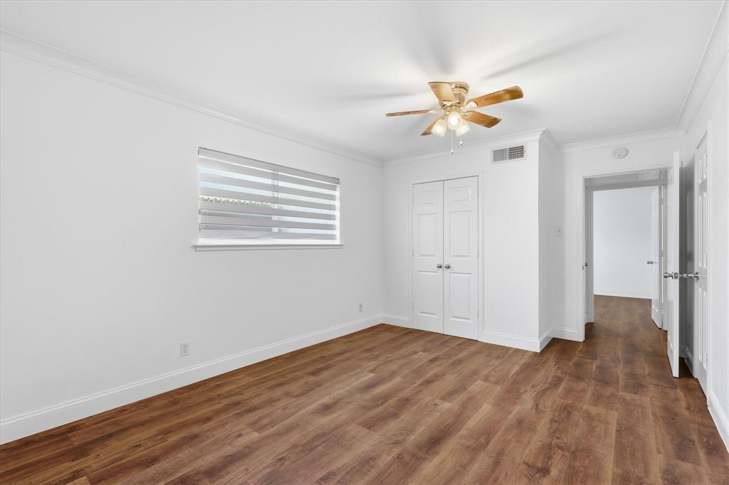 Spacious primary bedroom with updated flooring, fresh neutral paint and natural light from the window.
