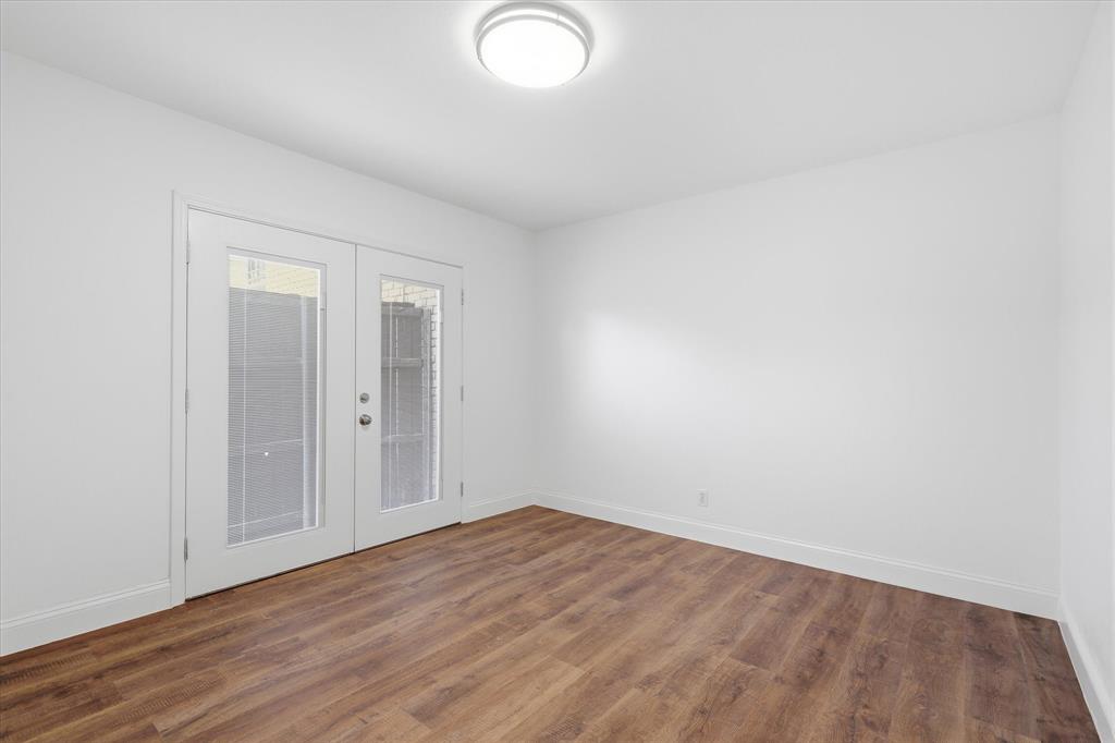Secondary bedroom with updated flooring, fresh paint and French doors opening to a private patio area is perfect for guests, an office,  study, craft or workout space with walk in closet.