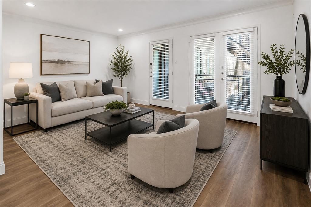 Virtually staged to showcase the spacious living area and provide a sense of furniture placement and scale. French doors bring in natural light and provide access to the outdoor patio area.