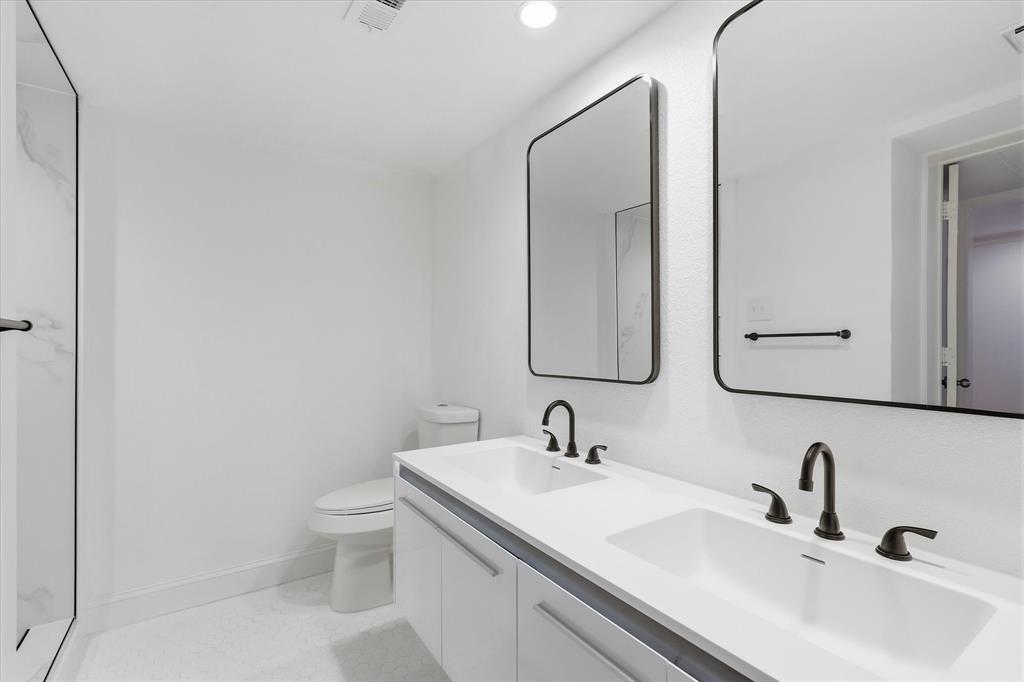 Remodeled bathroom with a double vanity, updated fixtures and contemporary finishes.