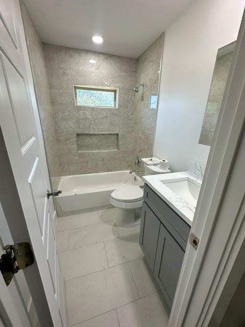 Bathtub with tiled surround and built-in niche, single vanity with under-sink storage, and recessed lighting Bathtub with tiled surround and built-in niche, single vanity with under-sink storage, and recessed lighting