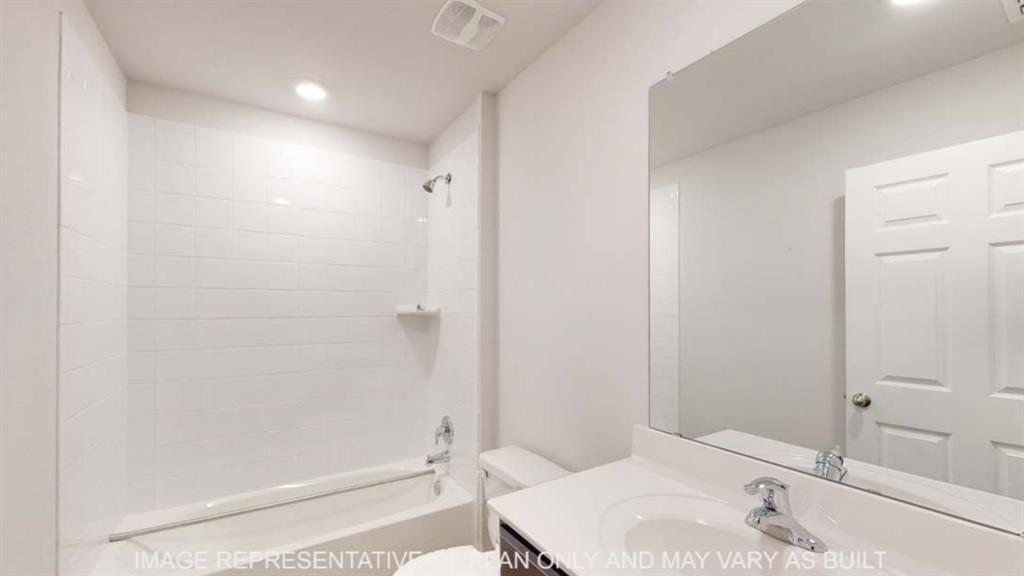 White subway tile shower surround with a built-in shelf, bathtub with chrome fixtures, single vanity with an integrated sink, and an expansive wall-mounted mirror