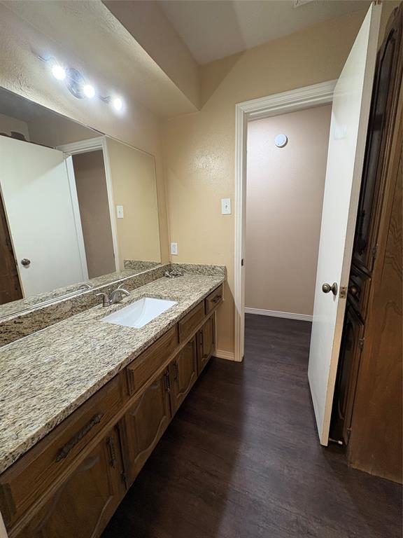 Dual vanity with a light-colored countertop and integrated sink, set against a full-width mirror