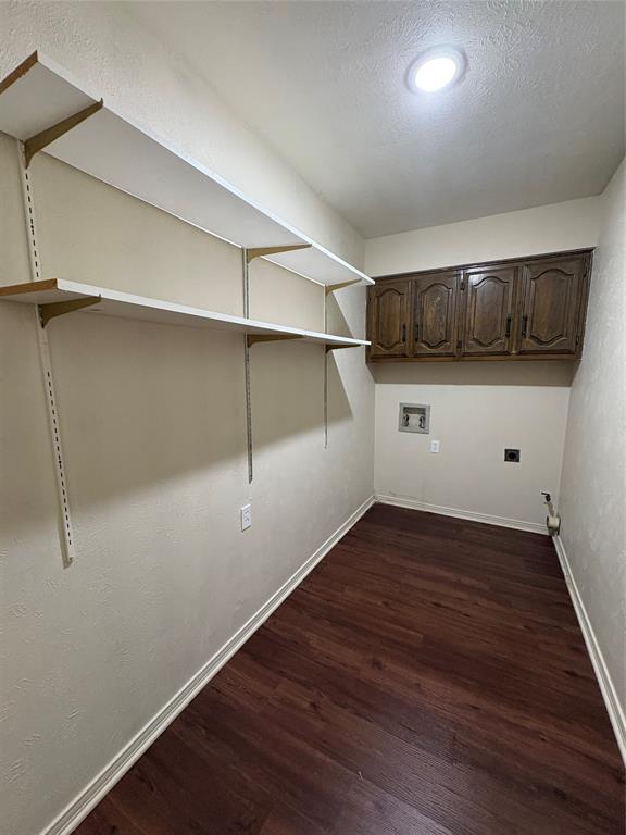 Wood-finish flooring with built-in shelving, overhead cabinetry, and recessed lighting