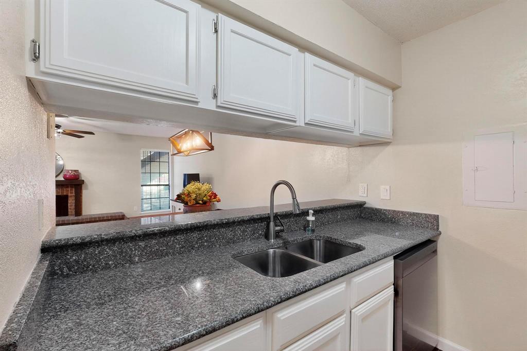 Kitchen featuring white cabinetry, gray speckled countertops, a double basin stainless steel sink with a high arc faucet, and a stainless steel dishwasher