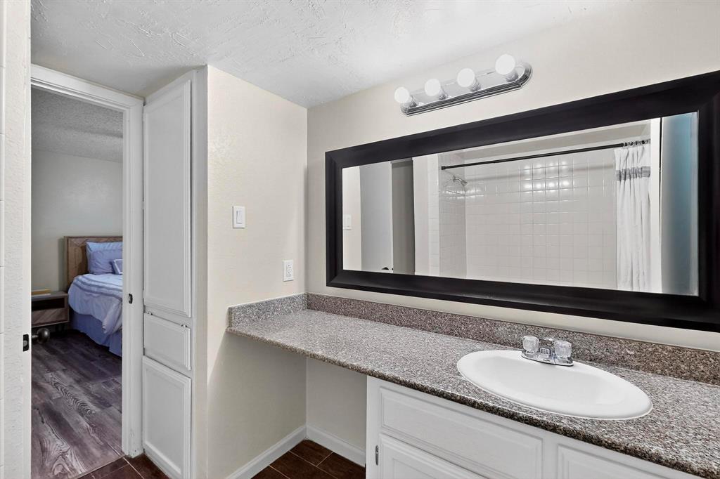Bathroom vanity with an undermount sink, a chrome faucet, and a speckled countertop