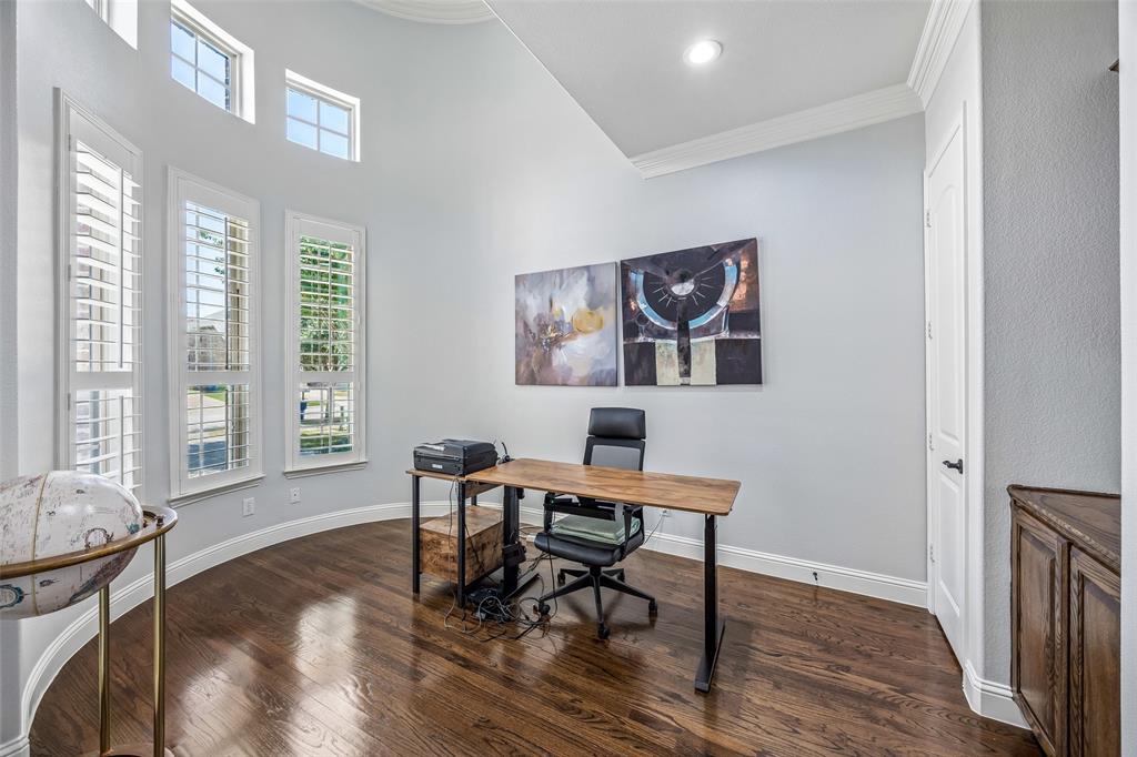 Office features built-ins, soaring ceilings and French doors