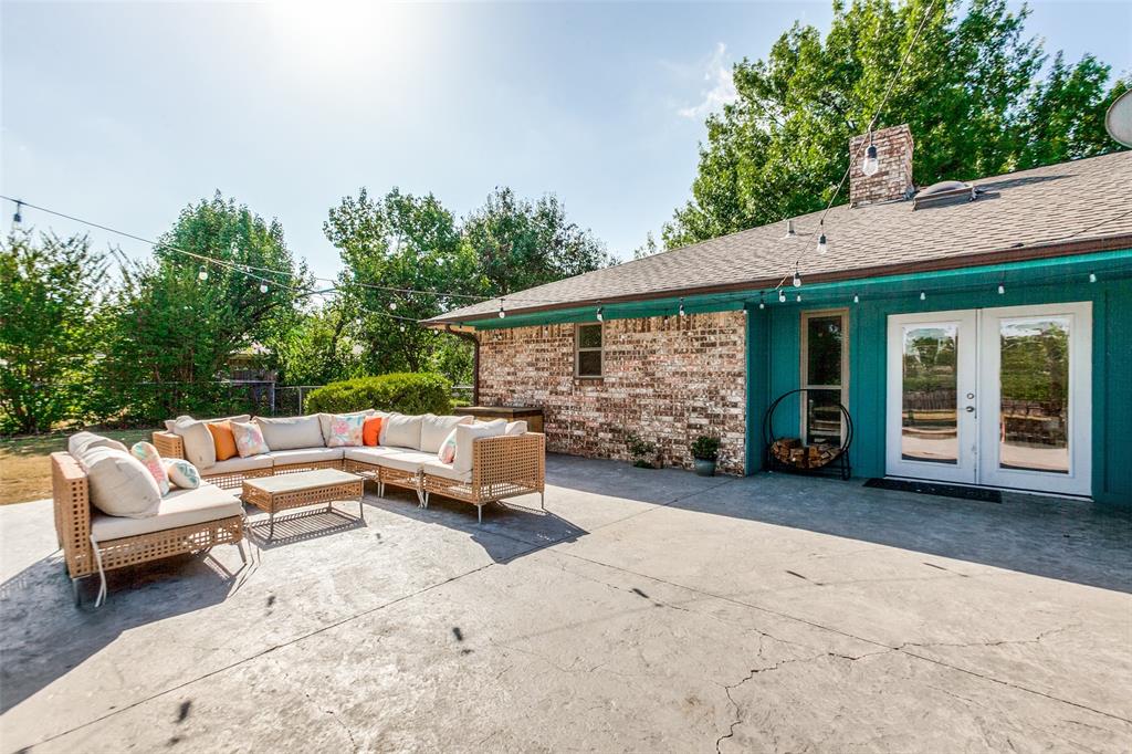 Expansive concrete patio with string lighting, brick exterior, and French doors Expansive concrete patio with string lighting, brick exterior, and French doors