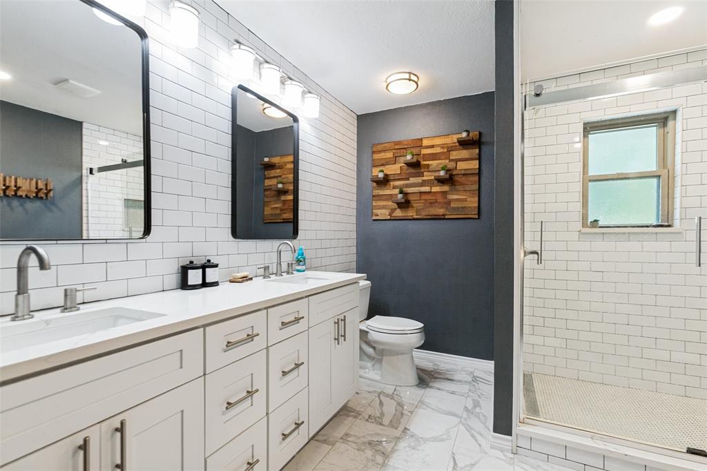 Dual vanity with white shaker-style cabinetry, undermount sinks, and contemporary wall-mounted lighting Dual vanity with white shaker-style cabinetry, undermount sinks, and contemporary wall-mounted lighting