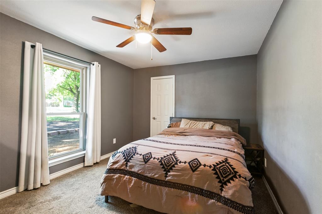 Carpeted flooring, ceiling fan, white trim, and a window with white curtains