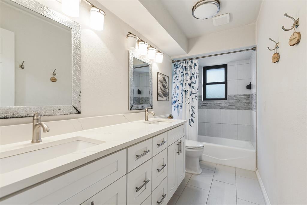 Dual vanity with integrated sinks, brushed nickel fixtures, and white cabinetry