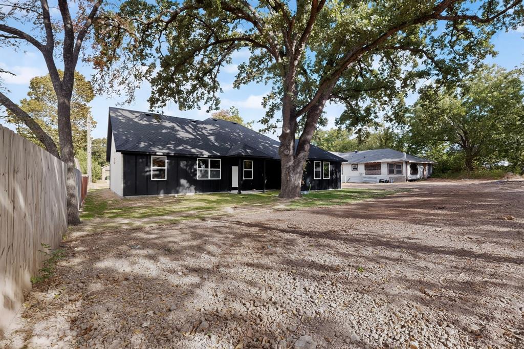 Black siding with white trim and a dark roof