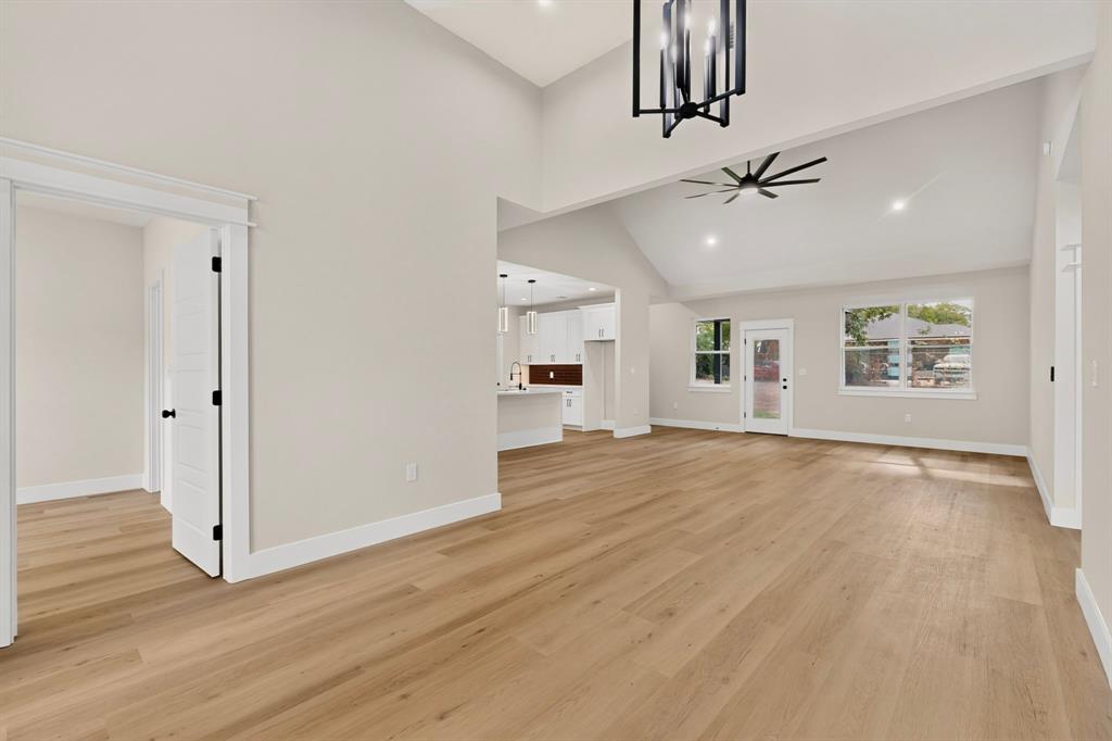 Vaulted ceilings, wood-finish flooring, recessed lighting, and a contemporary ceiling fan
