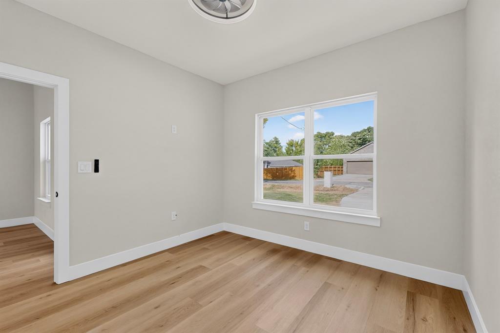 Wood-finish flooring, white window trim, white baseboards, and a ceiling-mounted light fixture