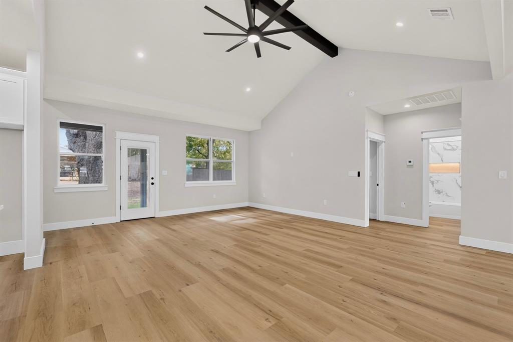 Vaulted ceilings with exposed beam, wood-finish flooring, recessed lighting, and a modern ceiling fan