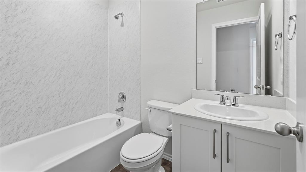 White vanity with a built-in sink, chrome fixtures, and a framed mirror