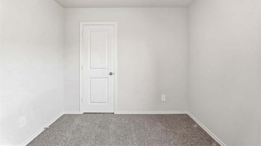 Plush carpeting, light-toned walls, and a white two-panel door