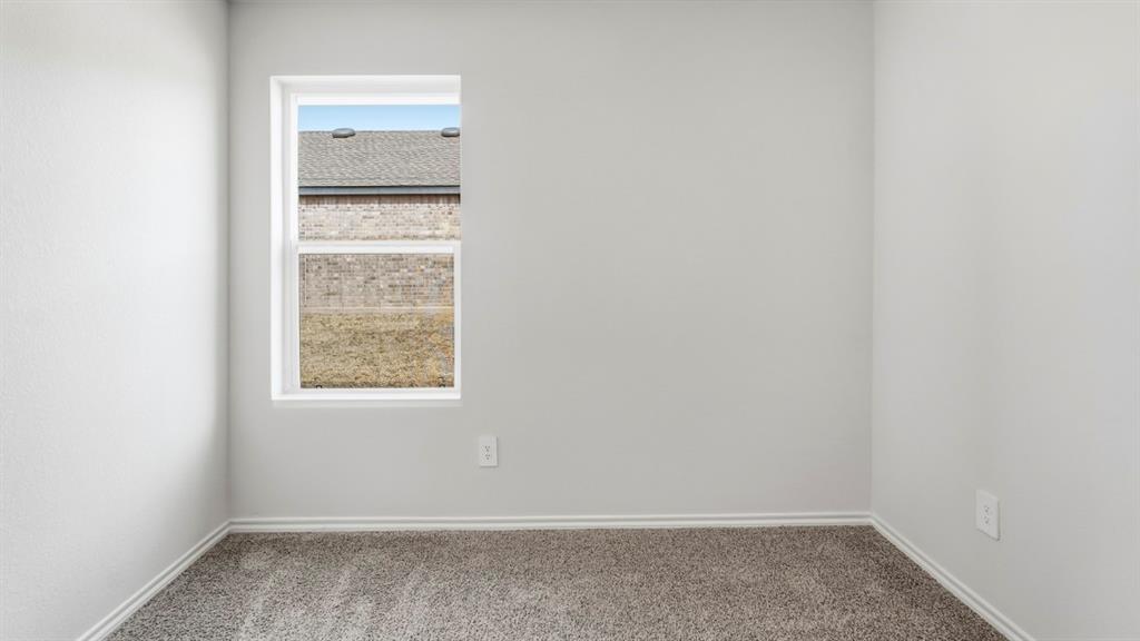 Light gray textured walls, gray carpeting, and a white-framed window