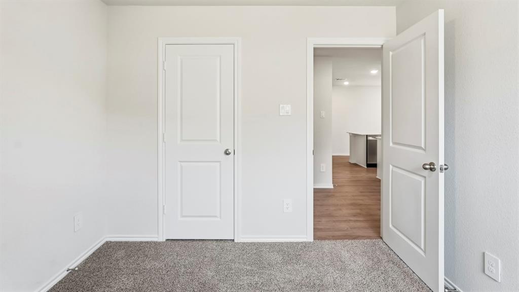 Textured carpeting and white interior doors with satin nickel hardware