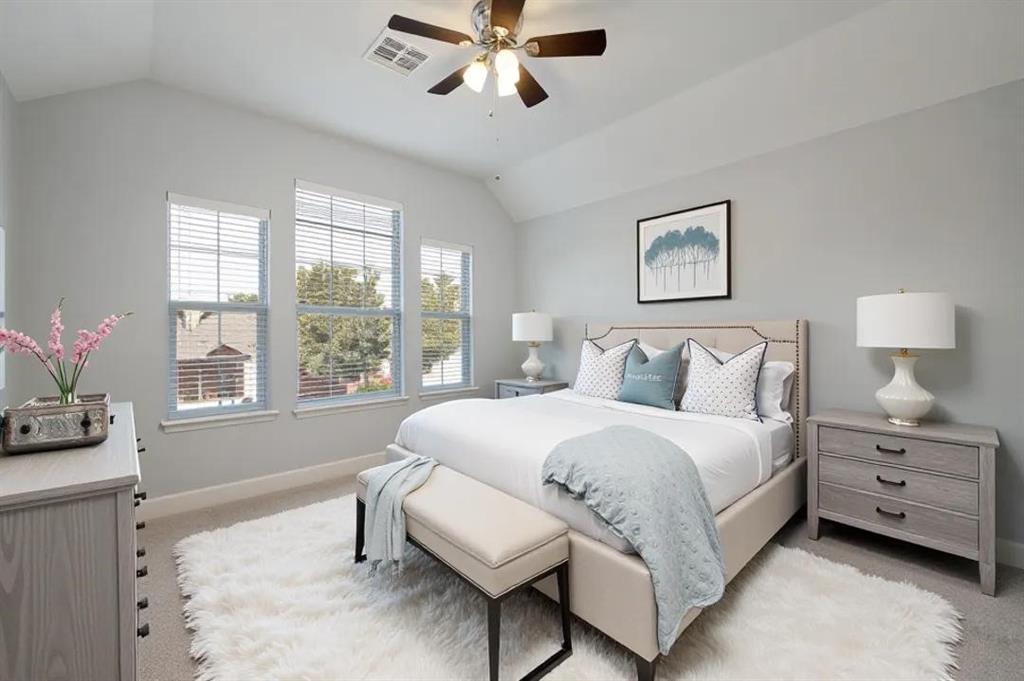 Vaulted ceiling with a ceiling fan, three windows with blinds, and light gray wall paint